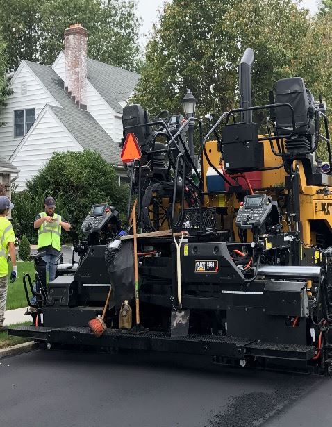 Truck paving residential street with new black top